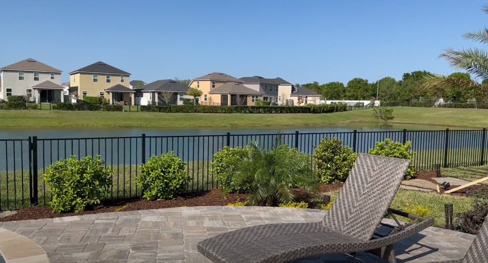 Lakefront property landscaping featuring paver patio and strategic privacy plantings Waterfront residential landscaping with paver patio and privacy plantings